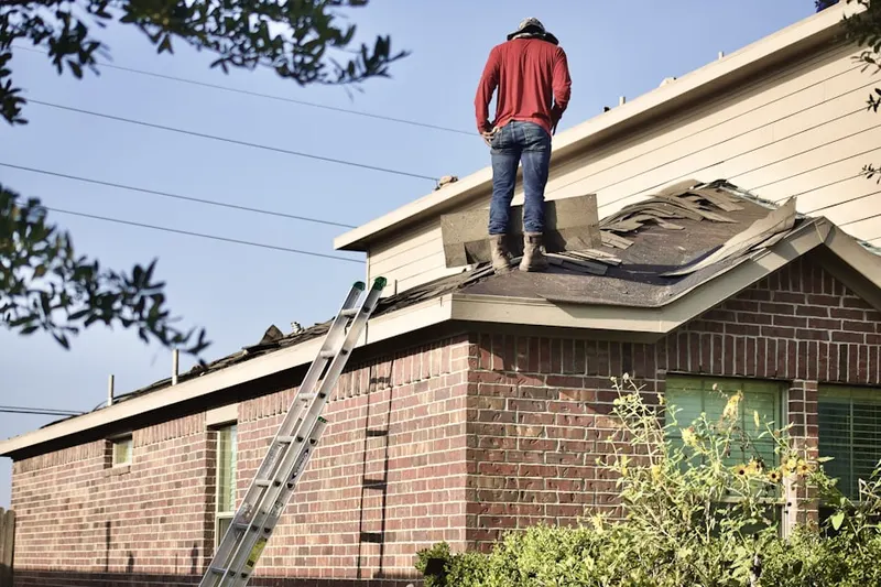 Professional roofer working on a residential roof in Marquette's Crossing West